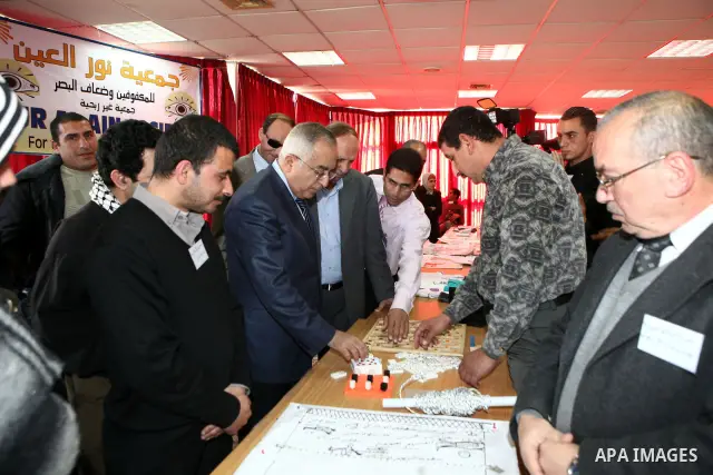 Palestinian Prime Minister Salam Fayyad visits the exhibition organized by Noor Al Ain "the light of eye" Association for the blind and visually impaired in the West Bank city of Ramallah on Dec. 18, 2011. Photo by Musta...
