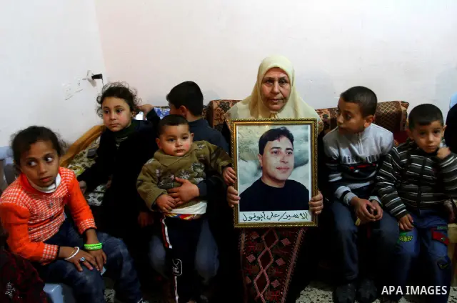 The mother of Palestinian prisoner Ali Abu Fool holds his picture before his release from an Israeli jail, in Gaza City December 18, 2011. Israel plans to release 550 Palestinian prisoners on Sunday in the second stage o...