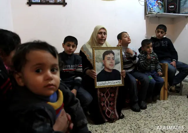 The mother of Palestinian prisoner Ali Abu Fool holds his picture before his release from an Israeli jail, in Gaza City December 18, 2011. Israel plans to release 550 Palestinian prisoners on Sunday in the second stage o...