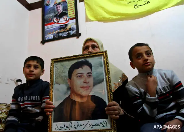 The mother of Palestinian prisoner Ali Abu Fool holds his picture before his release from an Israeli jail, in Gaza City December 18, 2011. Israel plans to release 550 Palestinian prisoners on Sunday in the second stage o...