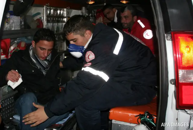 Palestinian medics help a wounded man during clashes with Israeli soldiers outside Ofer prison, near the West Bank city of Ramallah December 18, 2011. The clashes erupted while Palestinians gathered to wait for the relea...