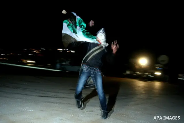 A Palestinian youth throws stones towards Israeli soldiers during clashes outside Ofer prison, near the West Bank city of Ramallah December 18, 2011. The clashes erupted while Palestinians gathered to wait for the releas...