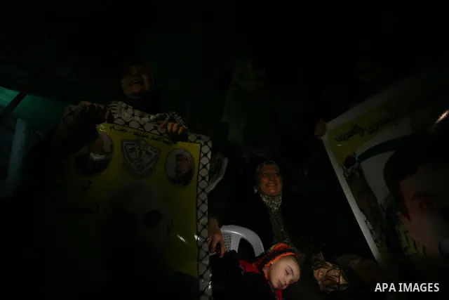 People celebrate as they wait for the release of Palestinian prisoners from Israeli jails at Rafah crossing in the southern Gaza Strip December 18, 2011. Israel plans to release 550 Palestinian prisoners on Sunday in the...