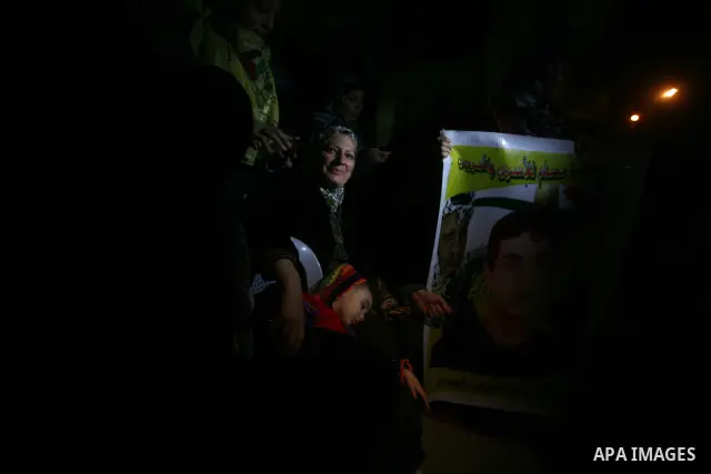 People celebrate as they wait for the release of Palestinian prisoners from Israeli jails at Rafah crossing in the southern Gaza Strip December 18, 2011. Israel plans to release 550 Palestinian prisoners on Sunday in the...