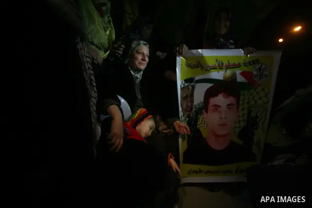 People celebrate as they wait for the release of Palestinian prisoners from Israeli jails at Rafah crossing in the southern Gaza Strip December 18, 2011. Israel plans to release 550 Palestinian prisoners on Sunday in the...