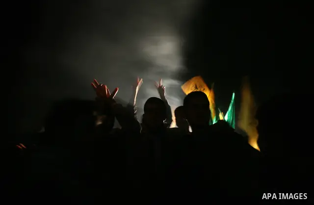 People celebrate as they wait for the release of Palestinian prisoners from Israeli jails at Rafah crossing in the southern Gaza Strip December 18, 2011. Israel plans to release 550 Palestinian prisoners on Sunday in the...