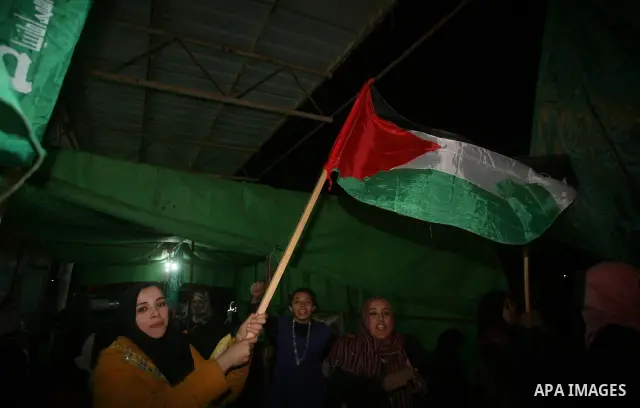 People celebrate as they wait for the release of Palestinian prisoners from Israeli jails at Rafah crossing in the southern Gaza Strip December 18, 2011. Israel plans to release 550 Palestinian prisoners on Sunday in the...