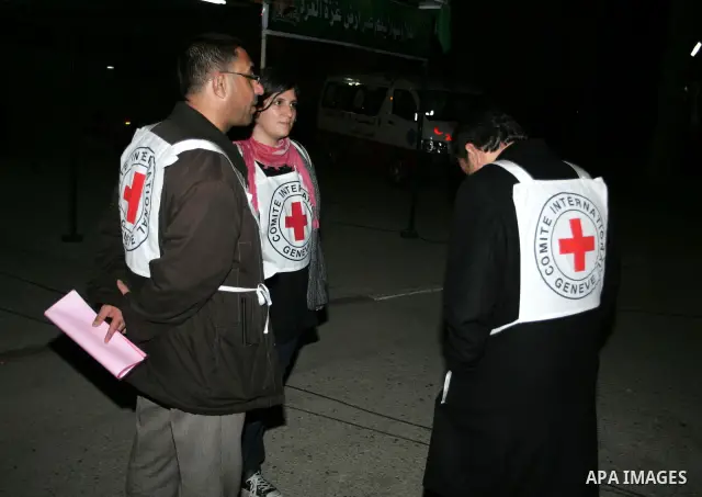 Members of Red Cross wait the Palestinian prisoners upon arrival at Rafah crossing in the southern Gaza Strip December 18, 2011. Israel plans to release 550 Palestinian prisoners on Sunday in the second stage of a deal w...