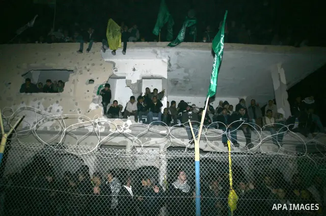 Palestinians celebrate as they wait for the release of Palestinian prisoners in Rafah, crossing in southern Gaza strip, on December 18, 2011. Israel plans to release 550 Palestinian prisoners on Sunday in the second stag...