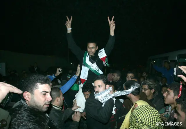 A freed Palestinian prisoners is greeted upon arrival at Rafah crossing in the southern Gaza Strip December 18, 2011. Israel plans to release 550 Palestinian prisoners on Sunday in the second stage of a deal with Hamas t...