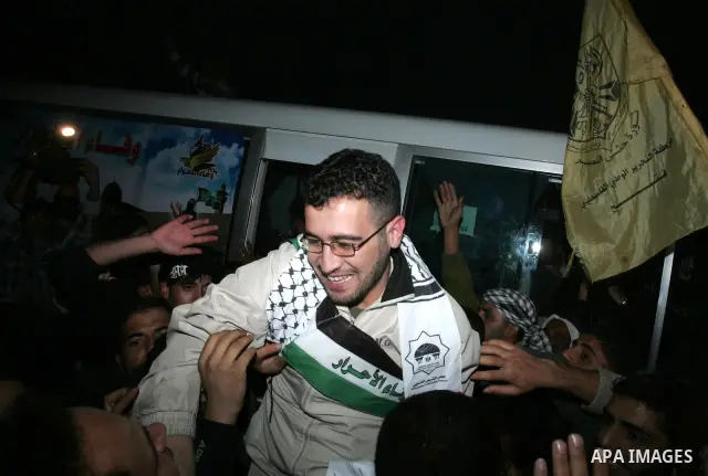 A freed Palestinian prisoners is greeted upon arrival at Rafah crossing in the southern Gaza Strip December 18, 2011. Israel plans to release 550 Palestinian prisoners on Sunday in the second stage of a deal with Hamas t...