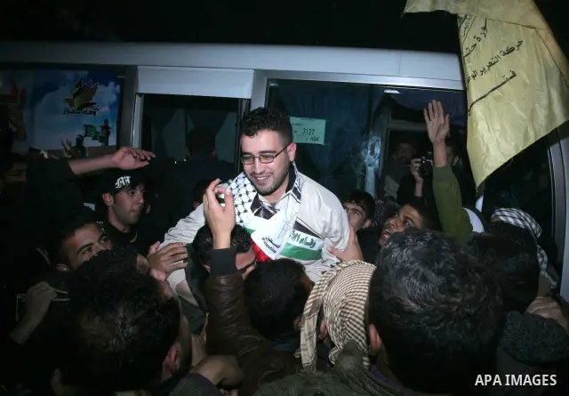 A freed Palestinian prisoners is greeted upon arrival at Rafah crossing in the southern Gaza Strip December 18, 2011. Israel plans to release 550 Palestinian prisoners on Sunday in the second stage of a deal with Hamas t...