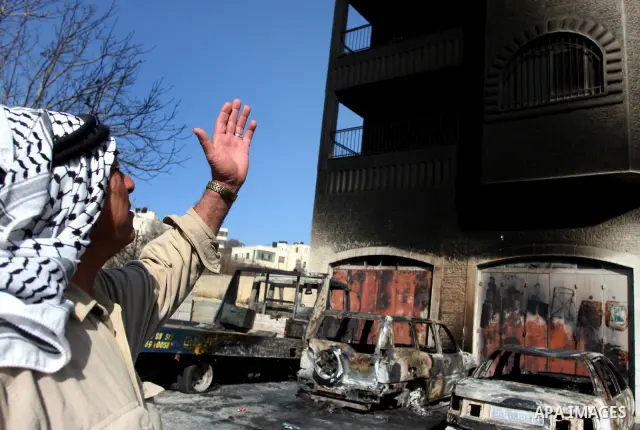 A Palestinian man inspects burnt cars after unidentified assailants torched them in the West Bank village of Beitin, north of Ramallah, on December 19, 2011 in a possible revenge attack by extremist Jews, police said. Ph...