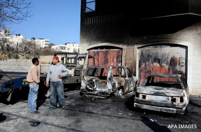 Palestinian men inspects burnt cars after unidentified assailants torched them in the West Bank village of Beitin, north of Ramallah, on December 19, 2011 in a possible revenge attack by extremist Jews, police said. Phot...