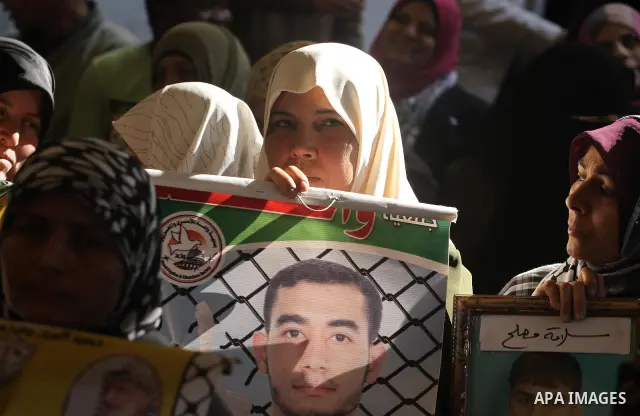 Palestinians women hold pictures of their prisoned relatives in Israeli jails as they gather in a weekly activity calling for their liberty at the Red Cross headquarters in Gaza City on Dec 19, 2011. About 7000 prisoners...