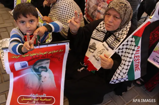 Palestinians women hold pictures of their prisoned relatives in Israeli jails as they gather in a weekly activity calling for their liberty at the Red Cross headquarters in Gaza City on Dec 19, 2011. About 7000 prisoners...