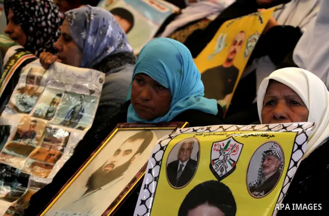 Palestinians women hold pictures of their prisoned relatives in Israeli jails as they gather in a weekly activity calling for their liberty at the Red Cross headquarters in Gaza City on Dec 19, 2011. About 7000 prisoners...