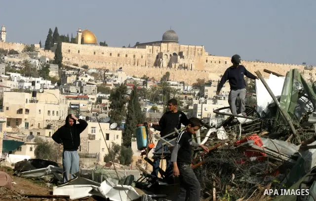 Palestinians sit on the rubble of a storehouse after an Israeli bulldozer destroys a storehouse in east Jerusalem neighborhood of Silwan on Dec 20,2011, where Palestinian houses are threatened to be demolished by the Isr...