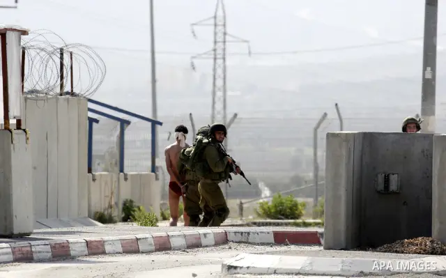 Israeli soldiers lead a stripped, blindfolded and handcuffed Palestinain youth to the back of the Huwara checkpoint after they suspected he was carrying explosives along with another boy near the West Bank city of Nablus...