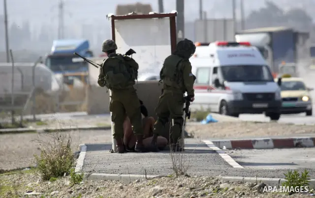 Israeli soldiers lead a stripped, blindfolded and handcuffed Palestinain youth to the back of the Huwara checkpoint after they suspected he was carrying explosives along with another boy near the West Bank city of Nablus...