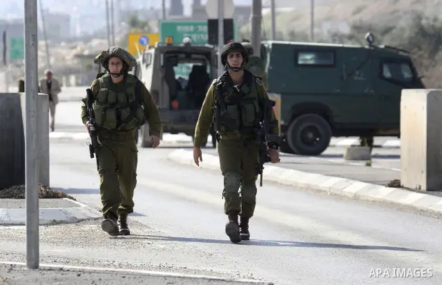 Israeli soldiers lead a stripped, blindfolded and handcuffed Palestinain youth to the back of the Huwara checkpoint after they suspected he was carrying explosives along with another boy near the West Bank city of Nablus...