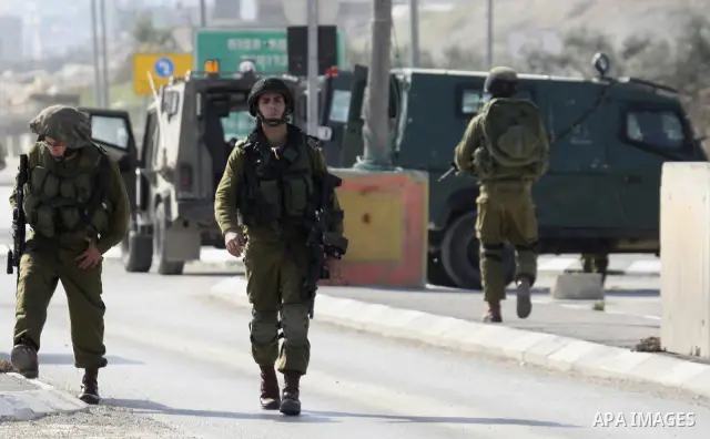 Israeli soldiers lead a stripped, blindfolded and handcuffed Palestinain youth to the back of the Huwara checkpoint after they suspected he was carrying explosives along with another boy near the West Bank city of Nablus...