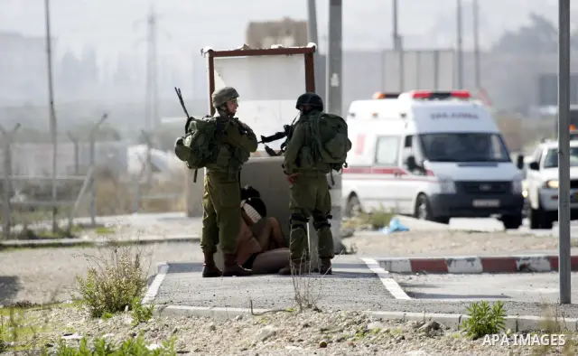 Israeli soldiers lead a stripped, blindfolded and handcuffed Palestinain youth to the back of the Huwara checkpoint after they suspected he was carrying explosives along with another boy near the West Bank city of Nablus...