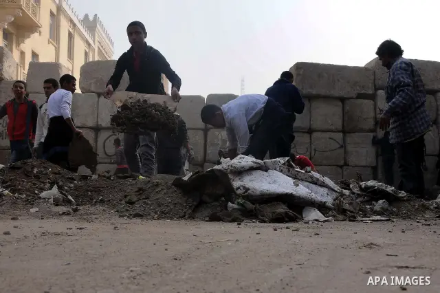 Egyptian protesters gather debris in a street by the Institute of Egypt, which was torched during protests, in central Cairo on December 20, 2011. Clashes between Egyptian security forces and protesters demanding an end...