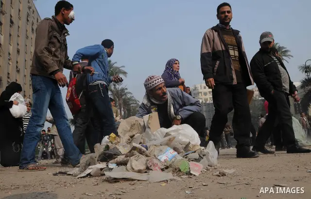 Egyptian protesters gather debris in a street by the Institute of Egypt, which was torched during protests, in central Cairo on December 20, 2011. Clashes between Egyptian security forces and protesters demanding an end...