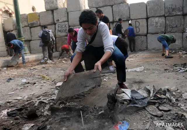 Egyptian protesters gather debris in a street by the Institute of Egypt, which was torched during protests, in central Cairo on December 20, 2011. Clashes between Egyptian security forces and protesters demanding an end...