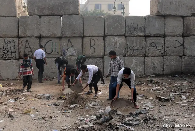 Egyptian protesters gather debris in a street by the Institute of Egypt, which was torched during protests, in central Cairo on December 20, 2011. Clashes between Egyptian security forces and protesters demanding an end...