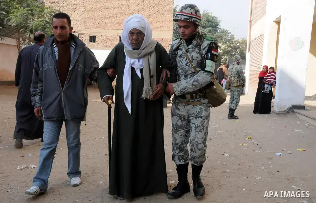 An old man is helped by army soldiers before casting his vote during the second round of parliamentary run-off elections at Imbaba in Giza, on the outskirts of Cairo December 21, 2011. Egyptians returned to the polls on...