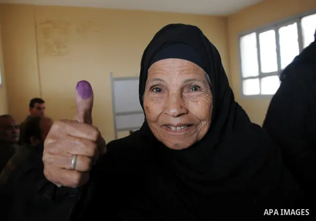 An Egyptian woman shows her ink-stained finger after she voted at a polling station in Giza district near Cairo on December 21, 2011 in the run-off of the second round of legislative election marred by deadly clashes bet...