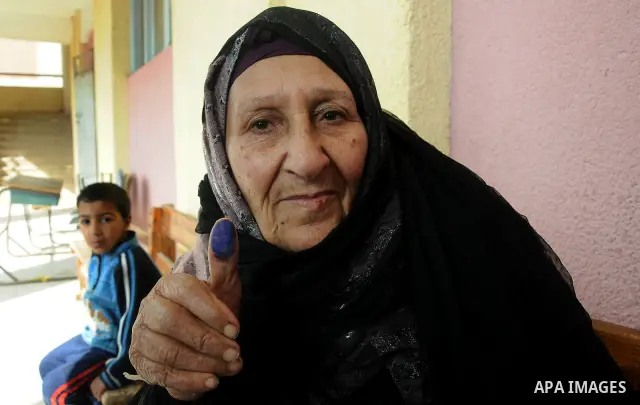 An Egyptian woman shows her ink-stained finger after she voted at a polling station in Giza district near Cairo on December 21, 2011 in the run-off of the second round of legislative election marred by deadly clashes bet...