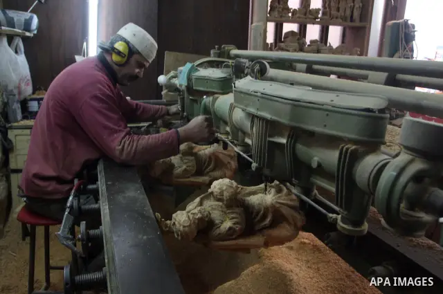 A Palestinian wood carver works on a nativity figurines are stored in an olive wood factory in the West Bank town of Bethlehem, ahead of Christmas,Thursday, Dec. 22, 2011. Photo by Issam Rimawi