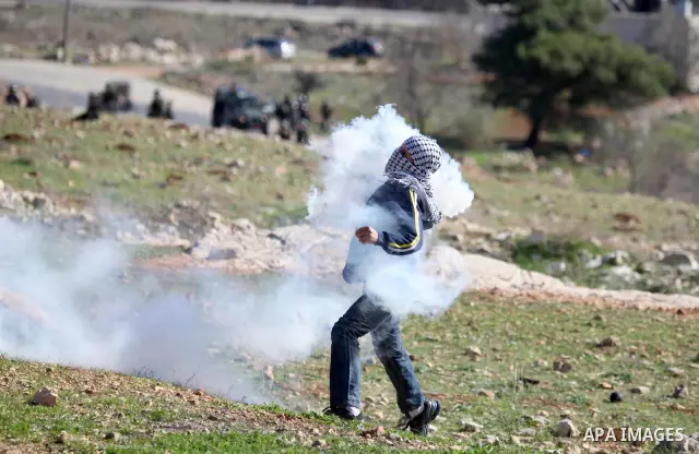 A Palestinian demonstrator hurls tear gas canister towards Israeli security forces during clashes at a weekly protest against a nearby Jewish settlement, in the West Bank village of Nabi Saleh, near Ramallah December 23,...