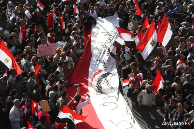 Supporters of the Egyptian military hold a giant Egyptian flag during a pro-military rally in Cairo's Abbassiya district on December 23, 2011. Thousands of anti-military protesters gathered in the nearby Tahrir Square to...