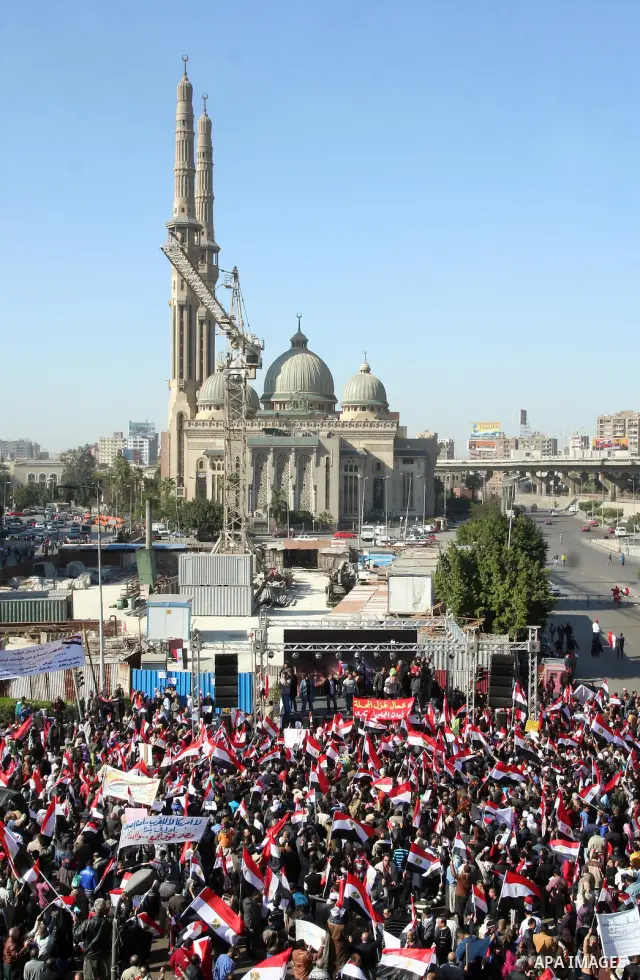Supporters of the Egyptian military hold a giant Egyptian flag during a pro-military rally in Cairo's Abbassiya district on December 23, 2011. Thousands of anti-military protesters gathered in the nearby Tahrir Square to...