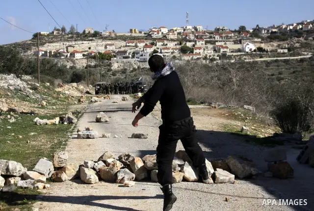 Palestinian youths hurl stones at Israeli security forces ,during a protest in the village of Kufr Qaddum near the Israeli settlement of Kdumim, in the northern West Bank, Friday, Dec. 23, 2011 . Photo by Wagdi Eshtayah.