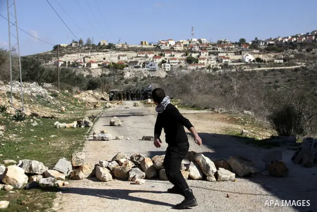 Palestinian youths hurl stones at Israeli security forces ,during a protest in the village of Kufr Qaddum near the Israeli settlement of Kdumim, in the northern West Bank, Friday, Dec. 23, 2011 . Photo by Wagdi Eshtayah.