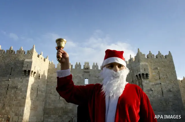 A Palestinian boy dressed-up in a Santa Claus costume walks on Jerusalem's Old City walls on December 24, 2011. Photo by Mahfouz Abu Turk