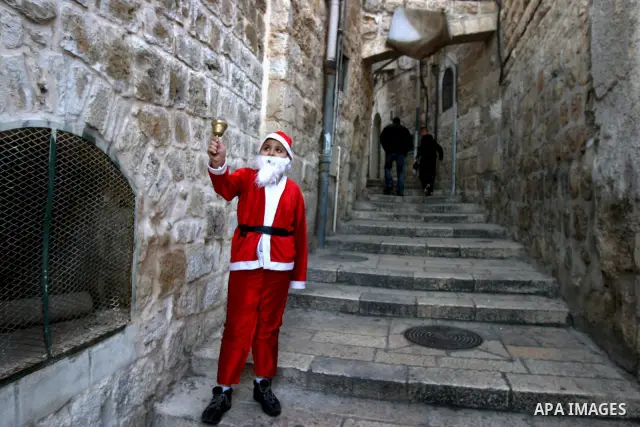 A Palestinian boy dressed-up in a Santa Claus costume walks on Jerusalem's Old City walls on December 24, 2011. Photo by Mahfouz Abu Turk