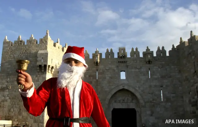 A Palestinian boy dressed-up in a Santa Claus costume walks on Jerusalem's Old City walls on December 24, 2011. Photo by Mahfouz Abu Turk