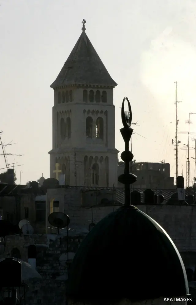 A Palestinian boy dressed-up in a Santa Claus costume,not seen' walks on Jerusalem's Old City walls on December 24, 2011. Photo by Mahfouz Abu Turk