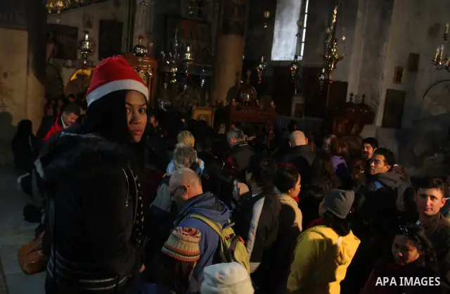 Christian pilgrims visit the Church of the Nativity in the biblical West Bank city of Bethlehem on Christmas Eve on 24 December 2011. Photo by Issam Rimawi