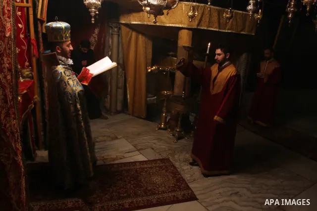 Christian pilgrims pray at the Grotto in the Church of the Nativity in the biblical West Bank city of Bethlehem on Christmas Eve on 24 December 2011. Photo by Issam Rimawi