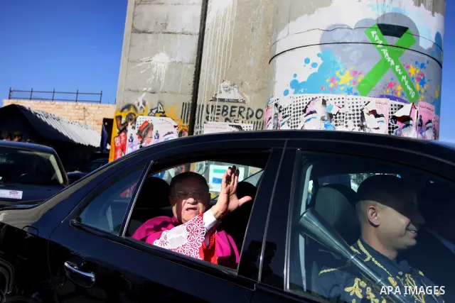 The head of the Roman Catholic Church in the Holy Land, the Latin Patriarch of Jerusalem Fuad Twal drives past the Israeli constructed separation barrier as he makes his way to the Church of the Nativity in the Biblical...