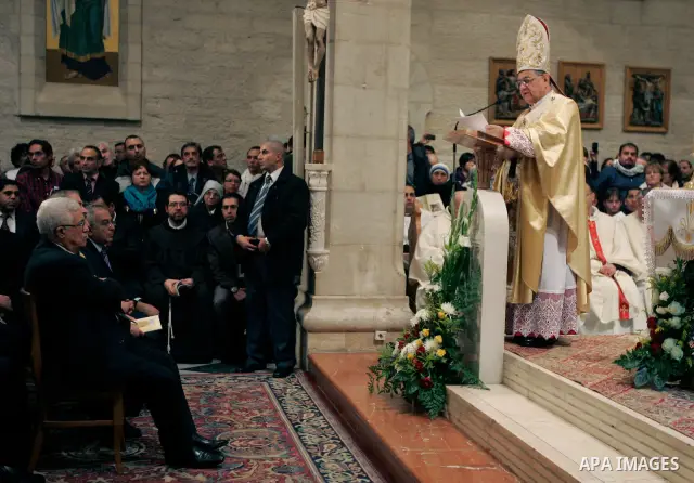 Palestinian President Mahmoud Abbas, left listens to Latin Patriarch of Jerusalem Fouad Twal hold the Christmas midnight Mass at the Church of the Nativity, traditionally believed to be the birthplace of Jesus Christ, in...