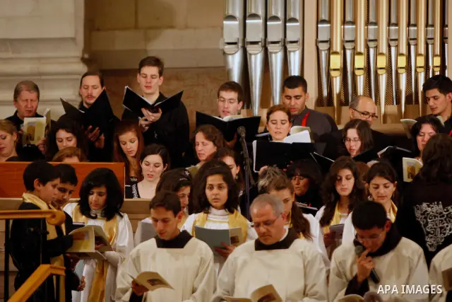 Members of Hungarian Saint Angela choir sing during the Christmas midnight Mass at the Church of the Nativity, traditionally believed to be the birthplace of Jesus Christ, in the West Bank town of Bethlehem early Sunday,...