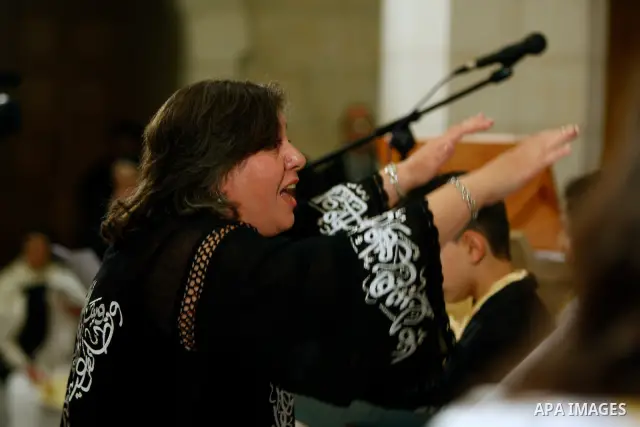 Gabriela Menus Semjen conducts the members of Hungarian Saint Angela choir during the Christmas midnight Mass at the Church of the Nativity, traditionally believed to be the birthplace of Jesus Christ, in the West Bank t...